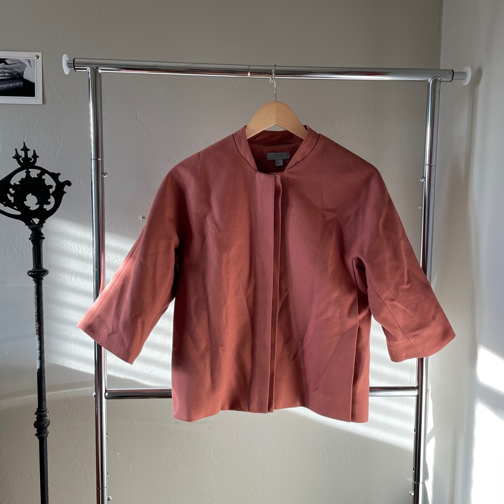 Salmon colored COS jacket.